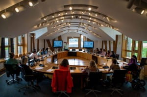 People sitting around an oval-shaped table taking part in a workshop